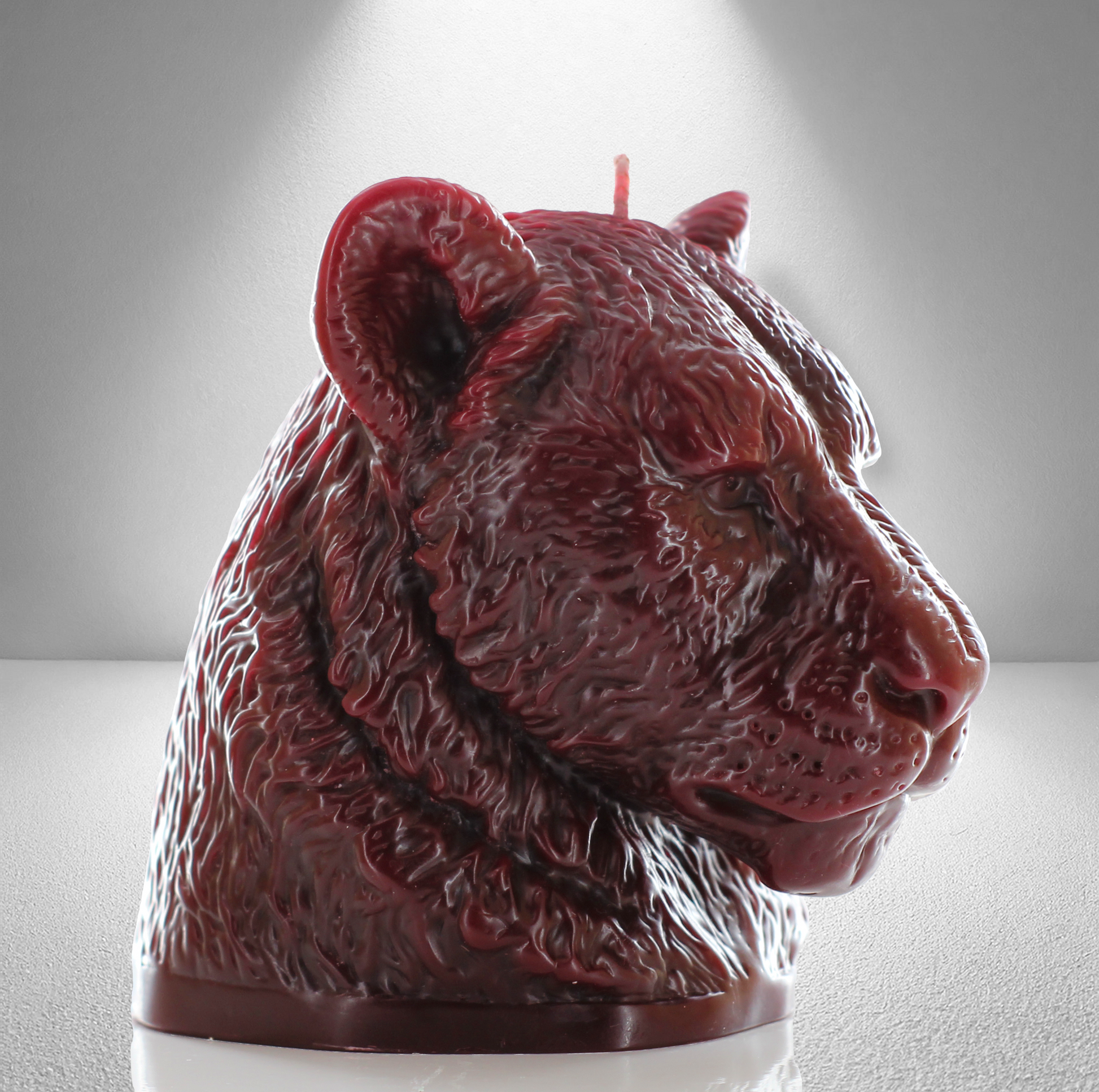 45 side view of bold dark red candle sculpted as a lioness head, showcasing detailed fur and a powerful, elegant design perfect for decor.