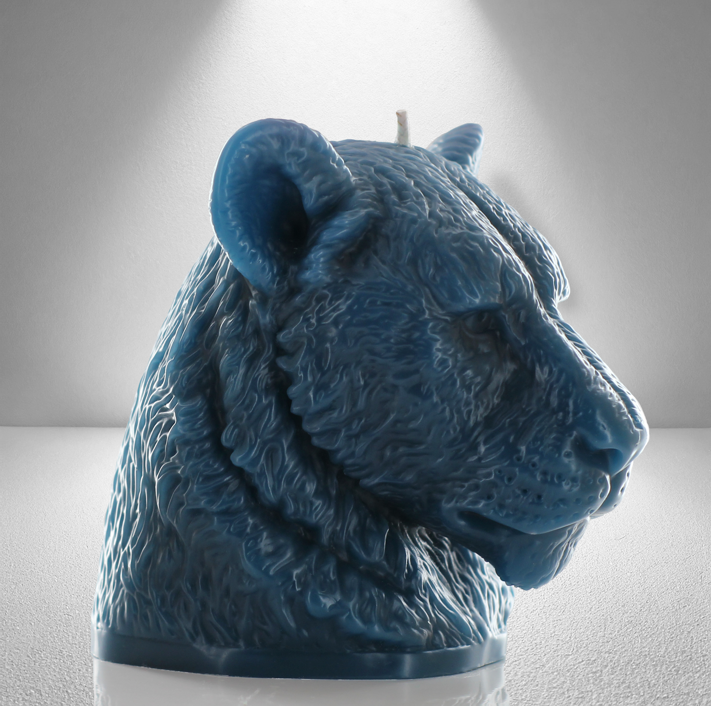 45 side view of bold teal candle sculpted as a lioness head, showcasing detailed fur and a powerful, elegant design perfect for decor.