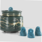 Fragranced wax melts shaped like detailed blue owls, displayed alongside a decorative wax warmer with a gold branch design.