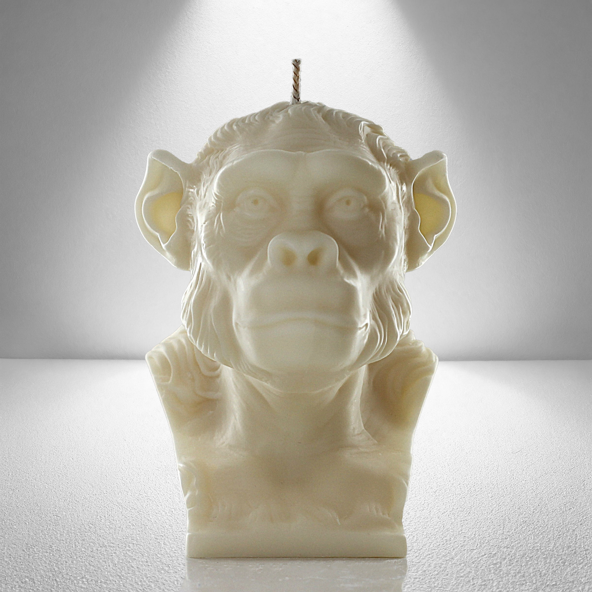 Front view of a soy unscented candle shaped like a chimpanzee, featuring detailed facial and fur textures. Bold and expressive design.