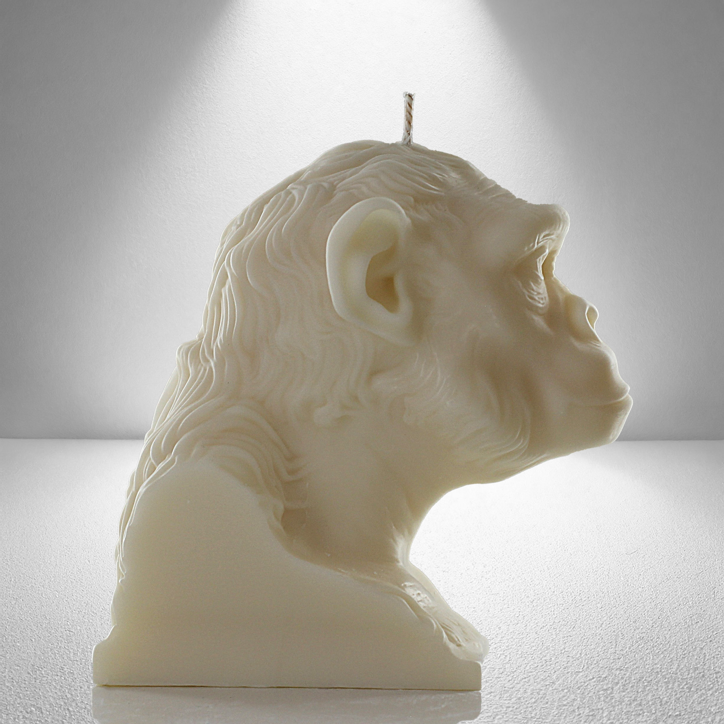 Complete side view of a soy unscented candle shaped like a chimpanzee, featuring detailed facial and fur textures. Bold and expressive design.
