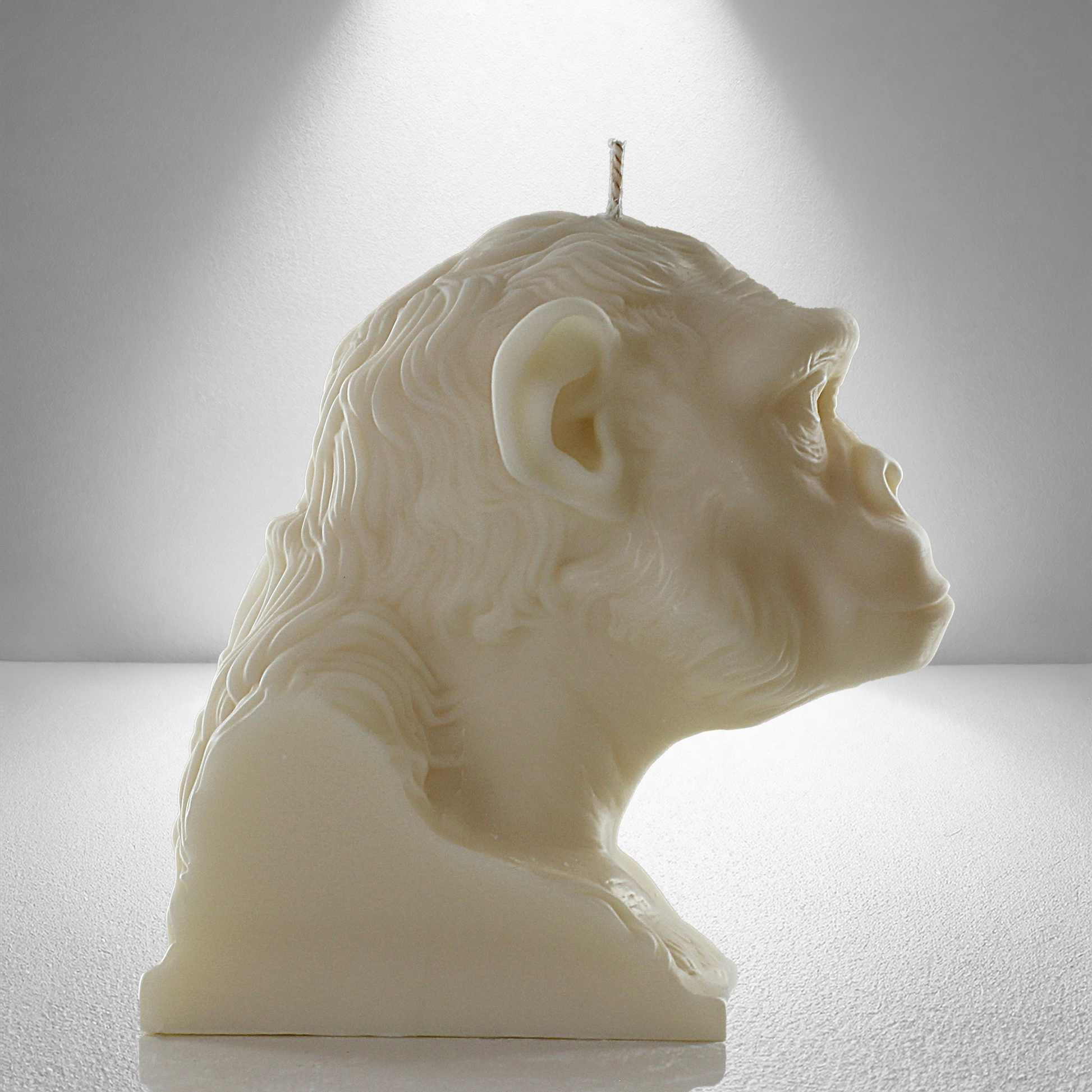 Complete side view of a soy unscented candle shaped like a chimpanzee, featuring detailed facial and fur textures. Bold and expressive design.