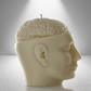Side view of a soy candle shaped like a human head with an exposed brain design, featuring a wick on top. Cream-colored and detailed.