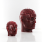 Red candle shaped like a human head with an exposed brain design, featuring a miniature version in the foreground as the main focus.