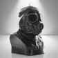 A dark grey military trooper bust candle with an intricate gas mask head design, displayed with a light grey backdrop under a spotlight.